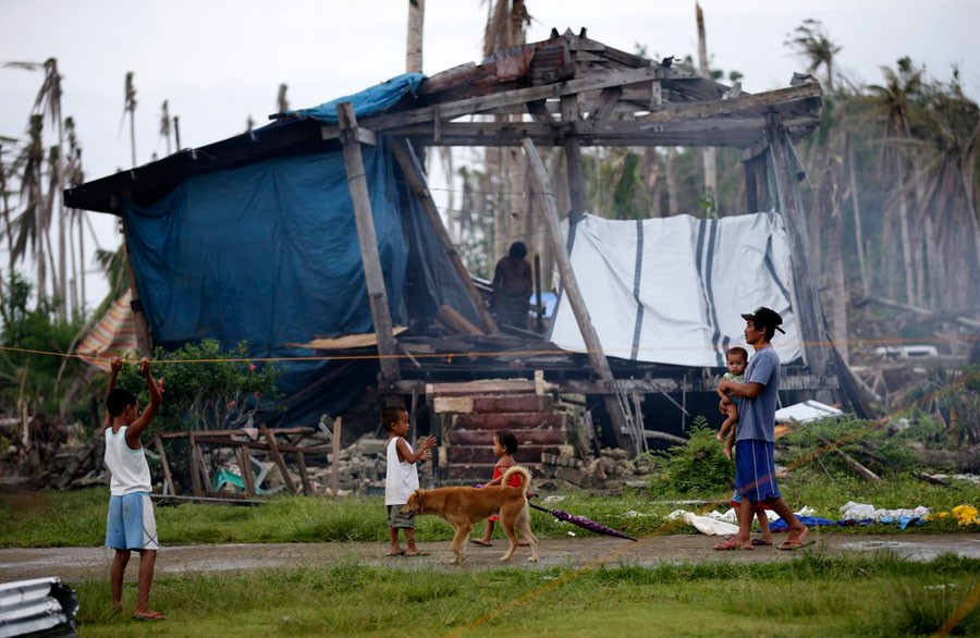 Sau trận siêu bão lịch sử Haiyan đổ bộ vào hồi tháng 11, cuộc sống của người dân Philippines trở nên khốn khó hơn bao giờ hết. Do vậy, năm nay họ cũng không còn háo hức chuẩn bị cho kì Giáng sinh. Trong ảnh, người cha trẻ đứng trước căn nhà tạm của mình ở ngôi làng Pagnamitan, đảo Calicuan thuộc tỉnh Tây Samar..